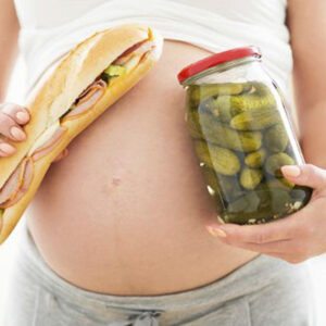 Mujer embarazada con alimentos en las manos