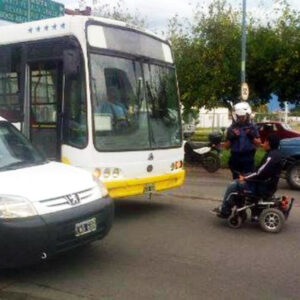 Hombre protesta frente a un autobus con s silla de ruedas