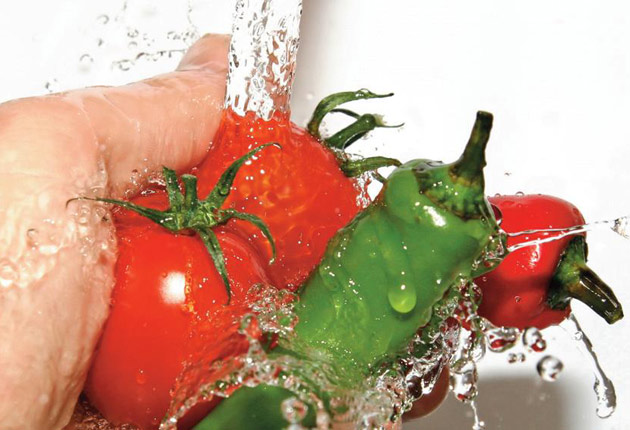 Manos lavando tomates 