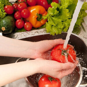 Manos lavando alimentos