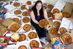 Mujer con muchas pizzas al rededor.