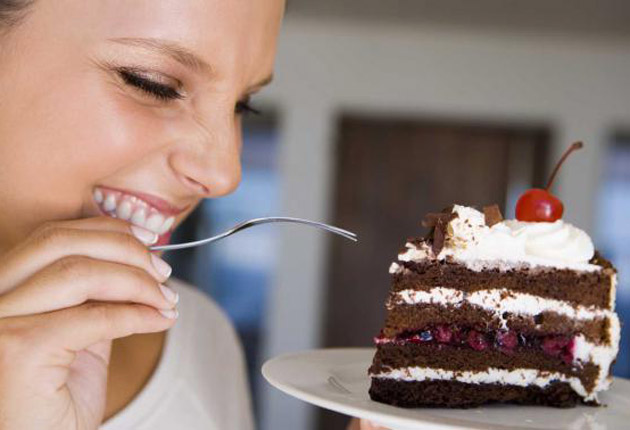 Mujer comiendo pastel.