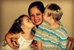 Una madre junto a sus dos hijos con Síndrome de Down.