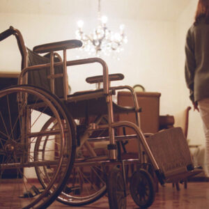 Mujer cerca de silla de ruedas.